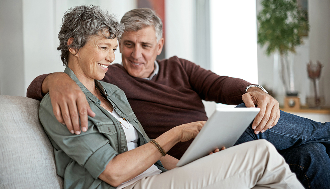 shot of a couple using a digital tablet while relaxing on their sofa