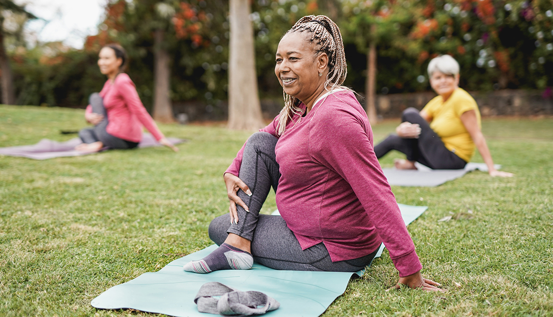 three women sitting on the ground stretching