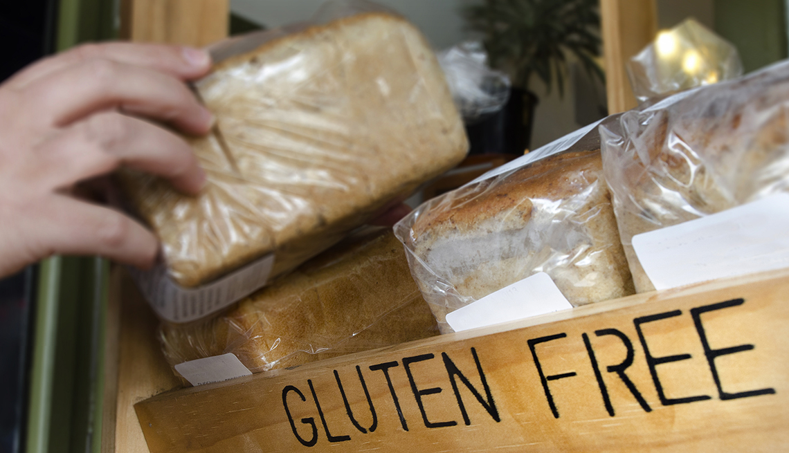 A hand picks up a gluten free loaf of bread