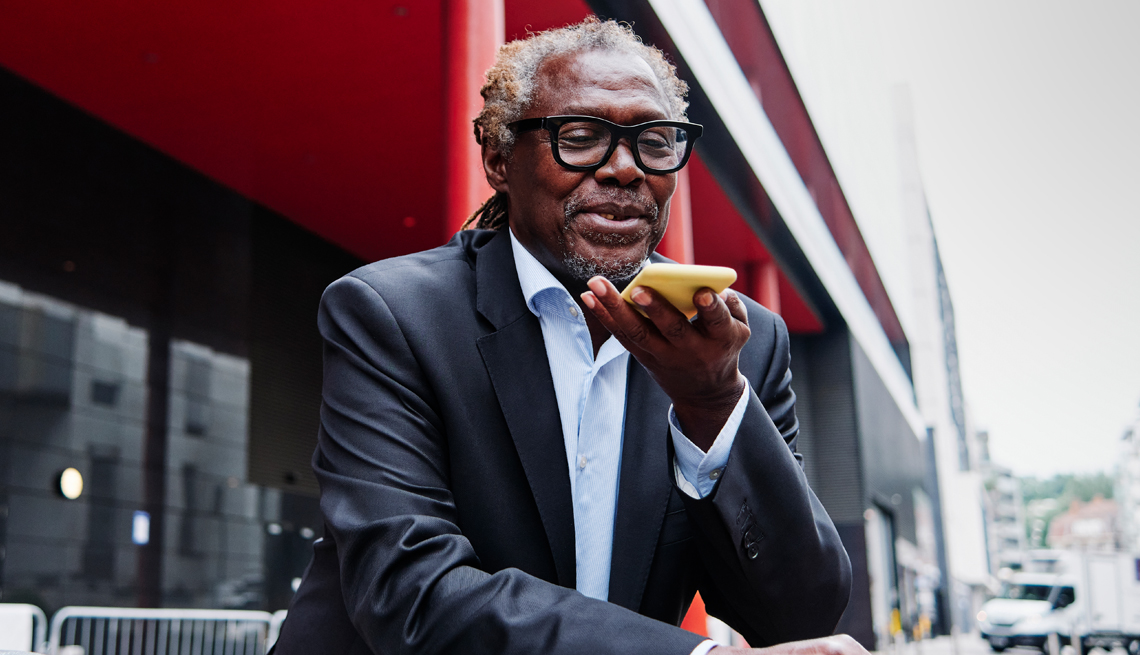 a man sitting and speaking into a phone to record speech to text