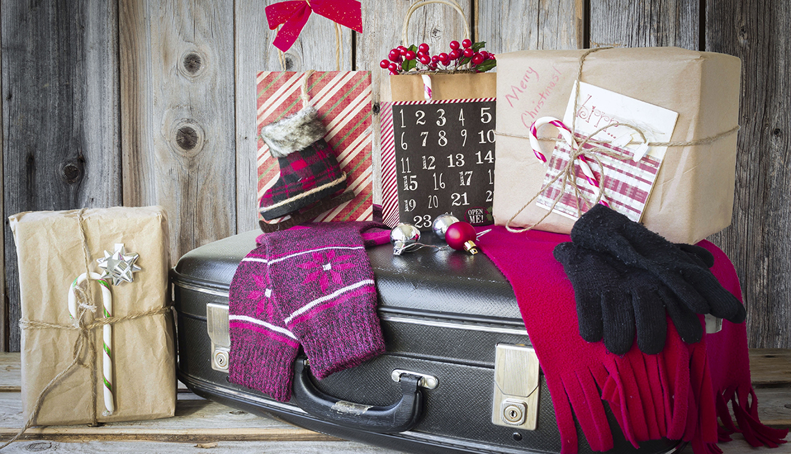 holiday gifts, gloves and scarf, on top and around black luggage