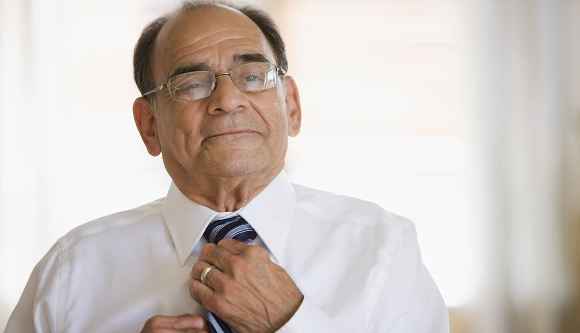 A man is tightening his tie