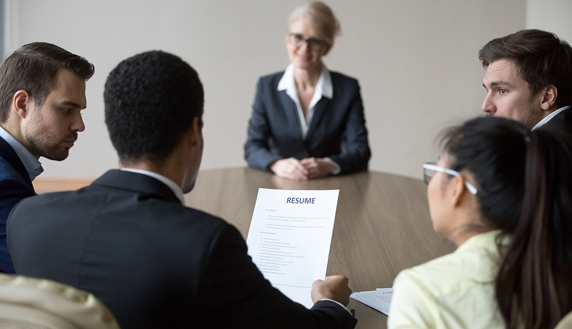 a group of people sitting around a table during a job interview