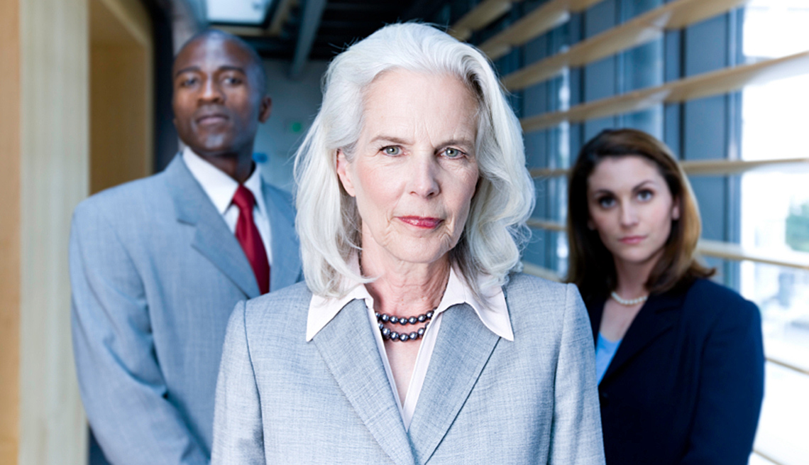 Mujer con jóvenes empresarios en el fondo