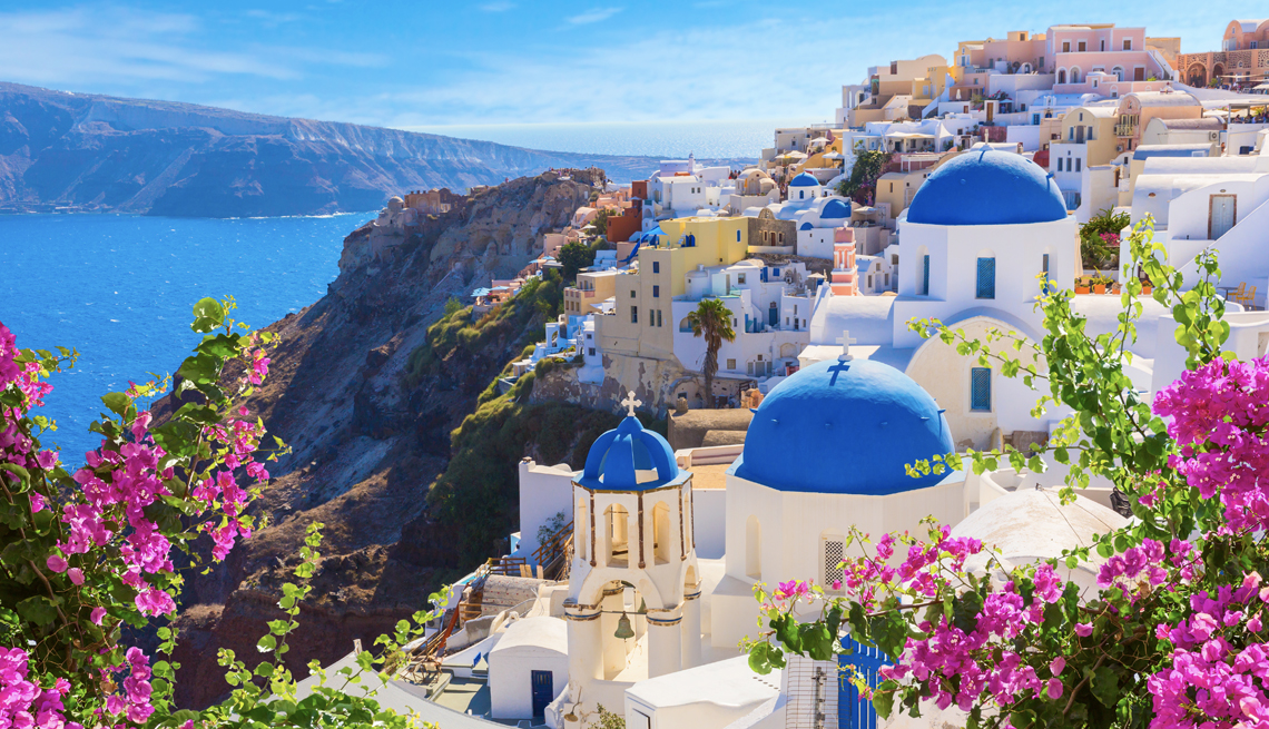 Flores frente a pintorescas edificaciones con techos azules en una isla